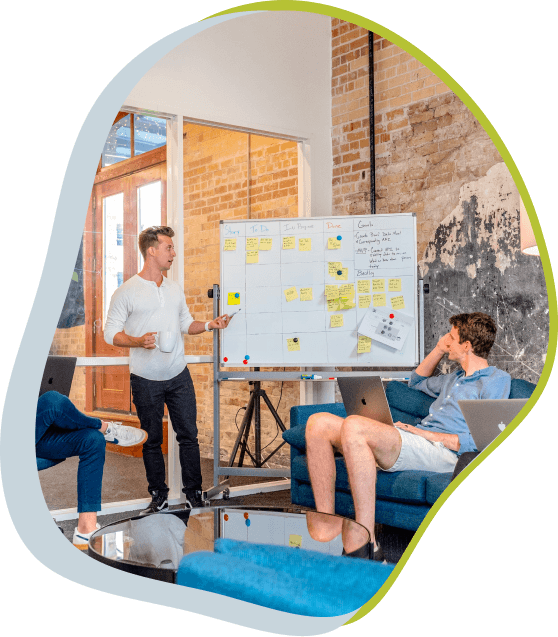 Três homens em reunião olhando para uma lousa com vários tickets de entrega